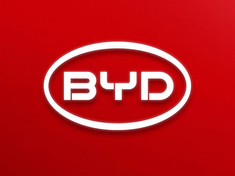 A white BYD Han electric vehicle quietly driving through a Beijing street, showcasing China’s new energy vehicle (NEV) technology and green mobility.