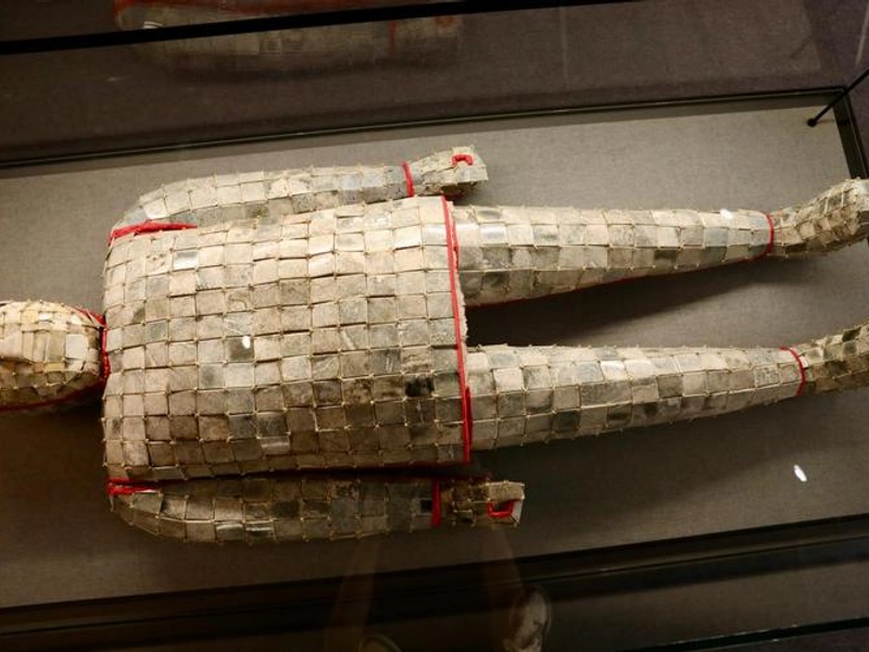 A Han Dynasty jade burial suit woven with gold thread, embodying the noble's dream of an incorruptible body and ascension to immortality.