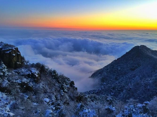 Mount Tai in Shandong at sunrise with clouds, temples, and ancient pine trees
