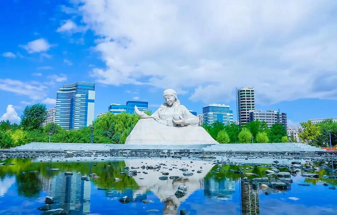 Modern skyline of Ordos city emerging from the edge of Kubuqi Desert