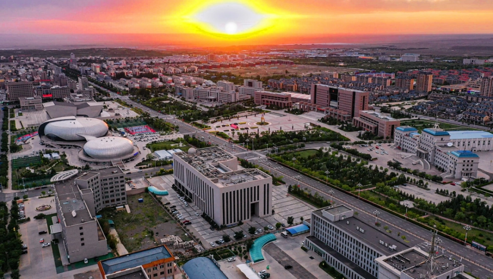 Golden poplar forest in Alxa desert with space launch facility in distance