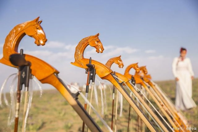 Mongolian musician playing horse-head fiddle in traditional costume