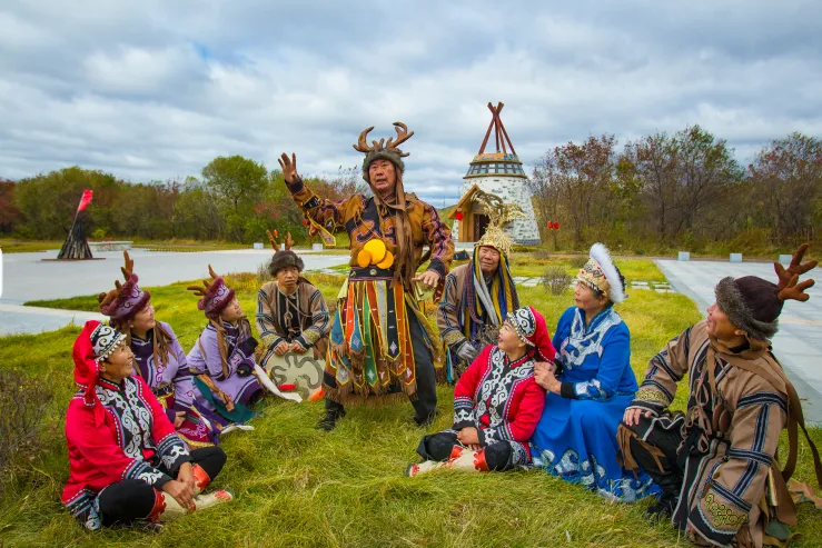 Hezhe elder performing Yimakan epic storytelling with traditional gestures