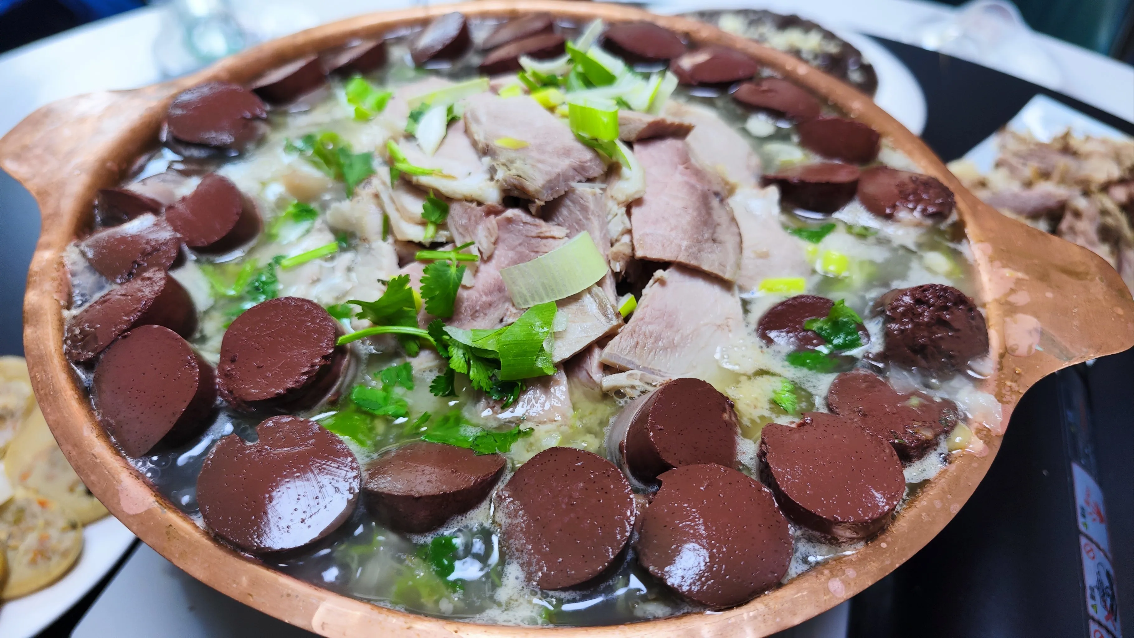 Traditional Sha Zhu Cai feast with pork belly and pickled cabbage in large pot