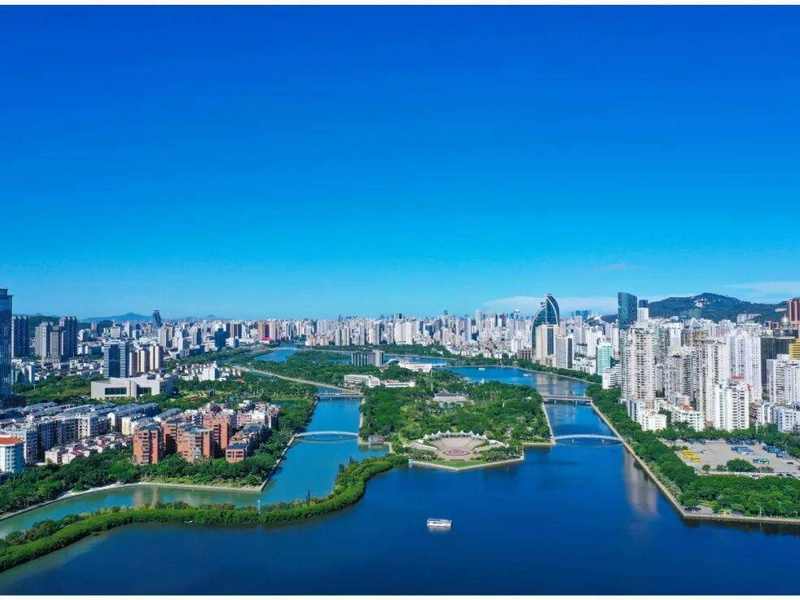 Aerial view of Xiamen with Gulangyu Island, colonial buildings, and blue coastline under sunlight