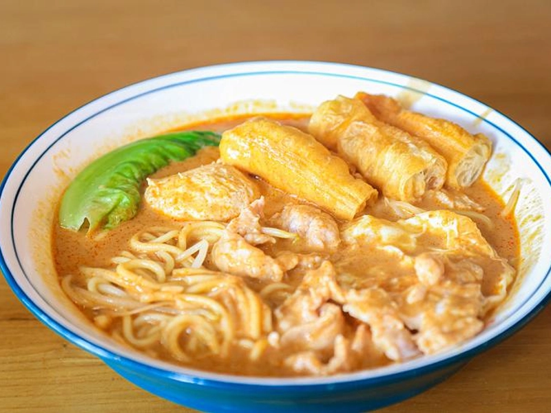 Xiamen Shacha noodles with rich sauce, seafood toppings and fresh herbs