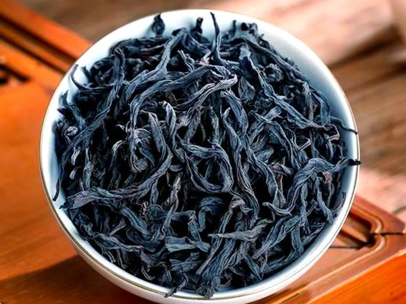 Wuyi Rock Tea leaves and brewing process showing dark roasted tea leaves