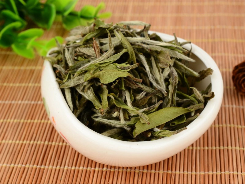 Fuding White Tea with silver needle leaves and pale golden liquor