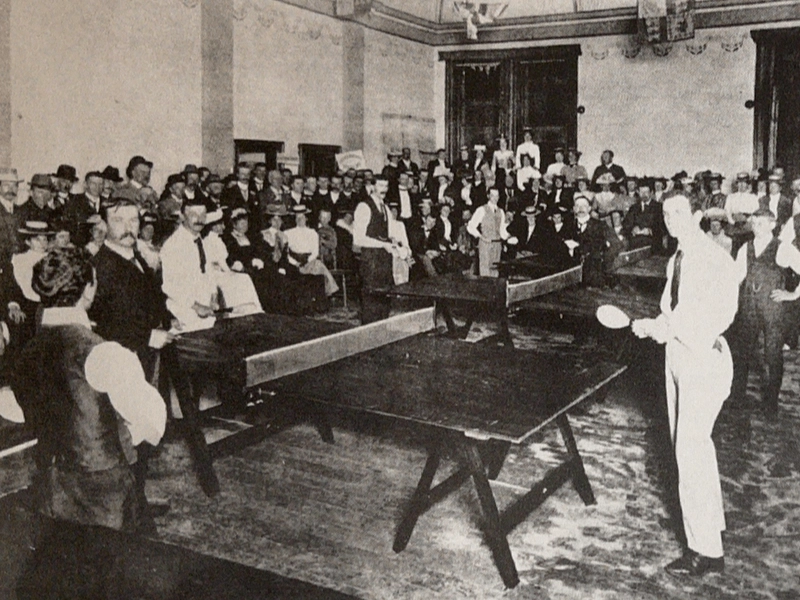 Victorian era British aristocracy playing early table tennis in parlor