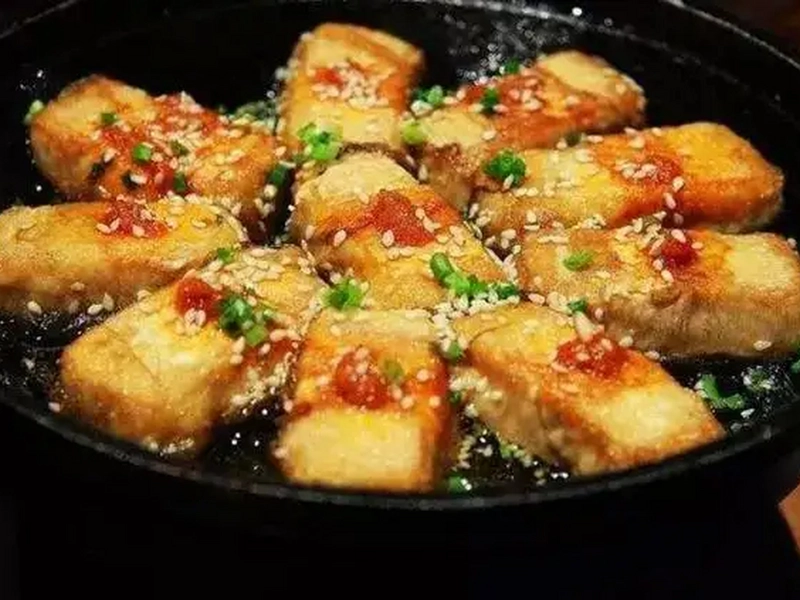 Mao Tofu with hairy exterior and soft interior, served with condiments