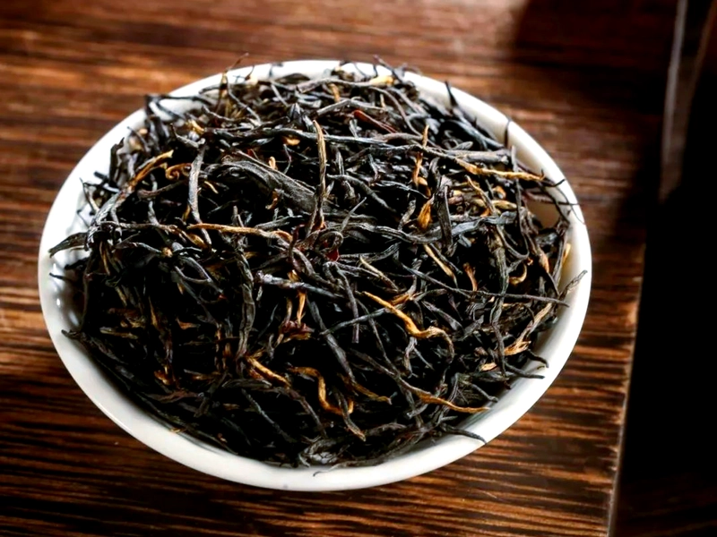 Qimen Black Tea with dark glossy leaves brewing into bright red liquor