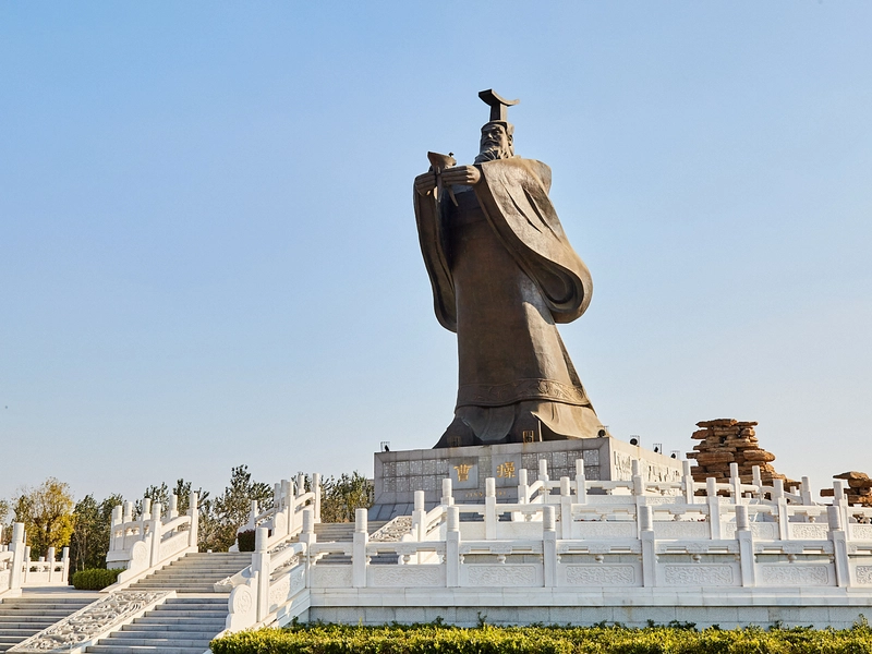 Cao Cao memorial or artistic depiction with scrolls and battlefield background, reflecting intellect and strategy