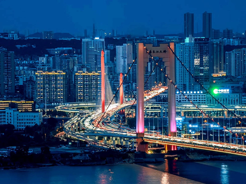 Panoramic view of Hubei showcasing the Yangtze and Han Rivers converging near Wuhan, with East Lake, Yellow Crane Tower, Mount Wudang peaks in the distance, reflecting the province’s rivers, mountains, cultural landmarks, and seasonal beauty.