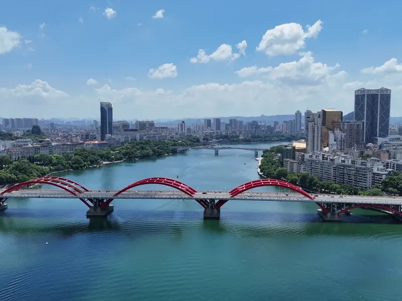 Liuzhou cityscape along the Liu River with mountains in the background, highlighting both industrial and natural beauty