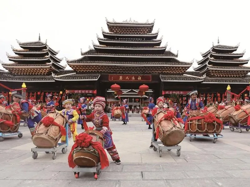 Dong village drum tower with tiered eaves, villagers singing grand songs in a chorus