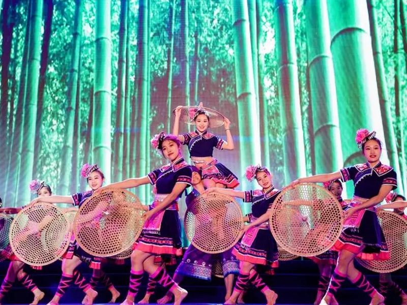 Maonan village homes built from stone, people celebrating the Fenlong Festival with drums and gongs