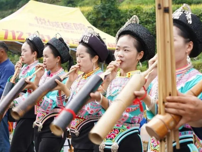 Shui family celebrating Duan Festival, making batik textiles by the river with traditional water-inspired patterns