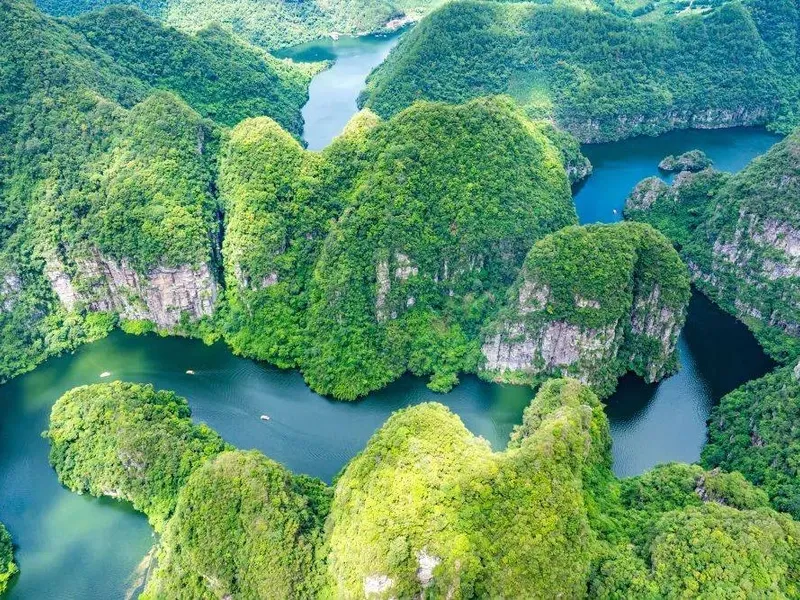 Jintang Saint Lake surrounded by mountains, mist rising in the morning, clear reflections of peaks on the water