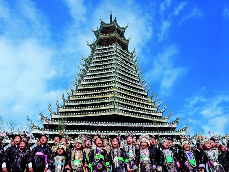 Dong people performing grand songs in a village drum tower, multiple voices harmonizing naturally