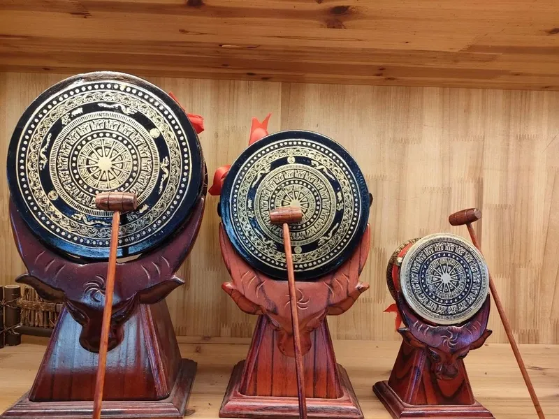 Zhuang bronze drum adorned with intricate carvings, producing resonant sound during a festival