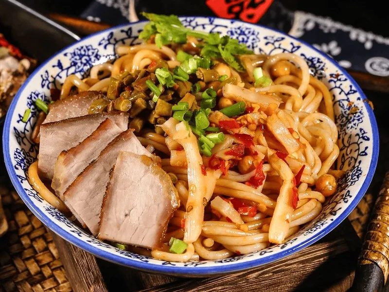 Bowl of Guilin rice noodles with pork, pickled bamboo shoots, peanuts, and scallions