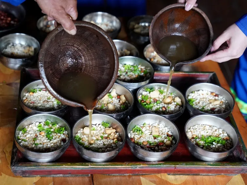 Yao oil tea served in a bowl with rice, sesame, and peanuts, symbolizing hospitality