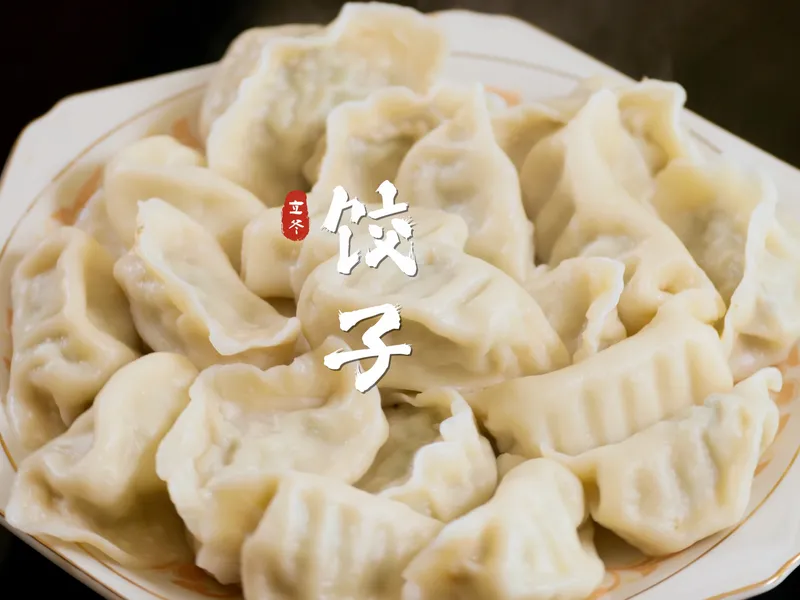 A steaming bowl of Chinese Jiaozi (dumplings), symbolizing the traditional 'Winter Filling' custom in Northern China during Lidong.