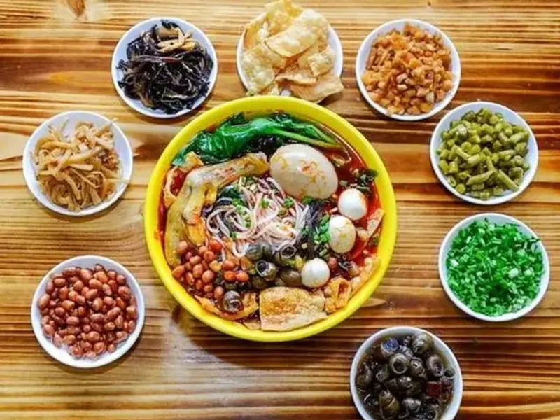Guangxi Street Food Trio: A vibrant image showcasing the three essential noodle dishes of Guangxi—a bowl of fresh Guilin Rice Noodles (Mifen), a steaming bowl of pungent Liuzhou Luosifen, and a spicy bowl of Nanning Old Friend Noodles—illustrating the best and cheapest authentic Chinese food of the Karst region.