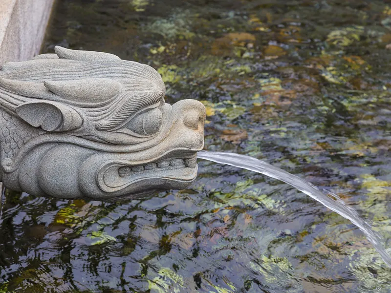 Artistic depiction of a Chinese water dragon swimming among waves and clouds