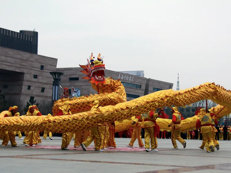 Chinese New Year dragon costume parade with performers holding poles beneath a long dragon