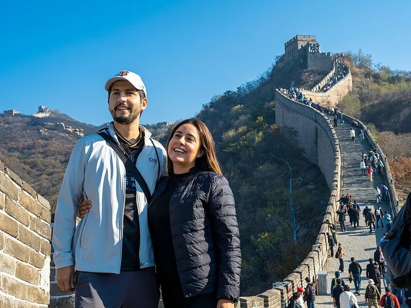 Tourists walking along the Great Wall, showcasing its cultural and scenic significance