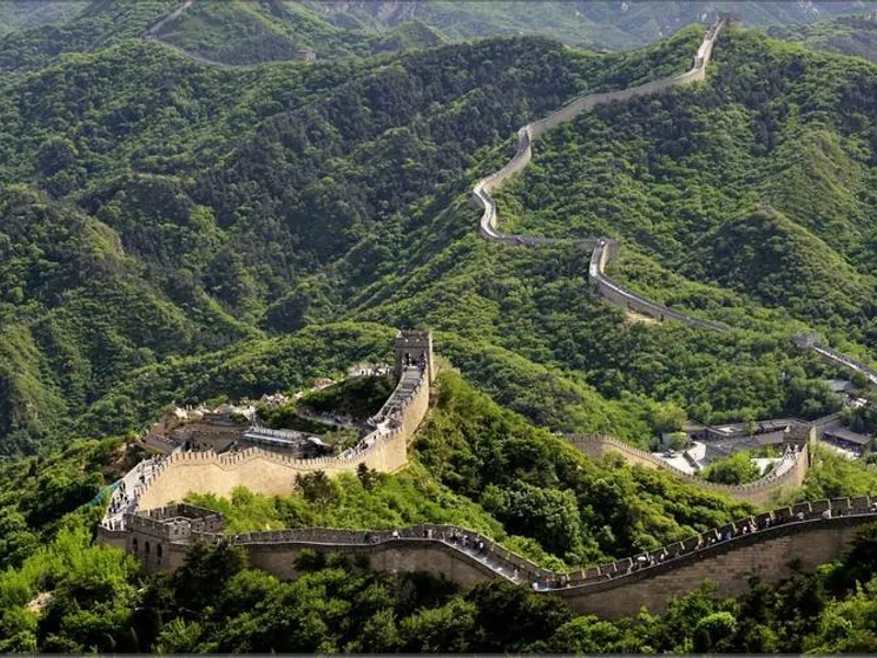 A breathtaking view of the Great Wall of China winding over misty mountains at sunrise, highlighting its towering watchtowers, ancient stone pathways, and the vast historical landscape that symbolizes human ingenuity, resilience, and cultural heritage.