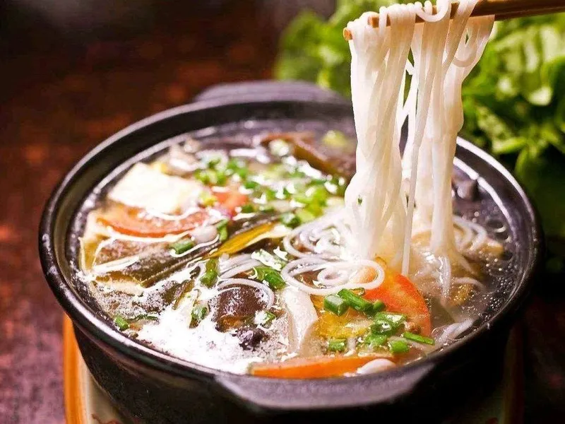 Yunnan crossing-the-bridge noodles with broth and raw ingredients