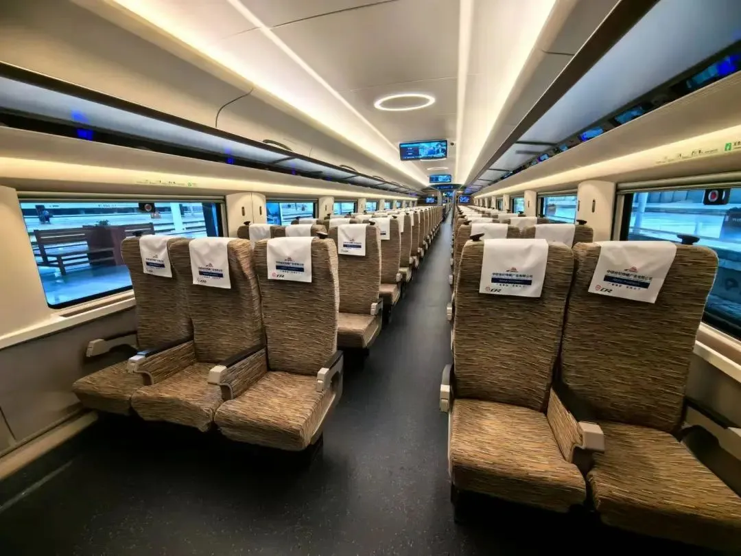 High-speed bullet train departing from a busy modern Chinese station, symbolizing connectivity and economic growth.