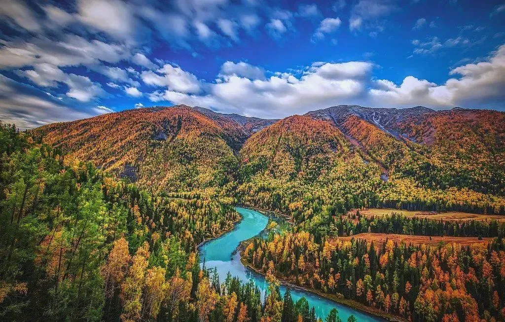 Kanas Lake in November, snow dusted pine forests and blue lake