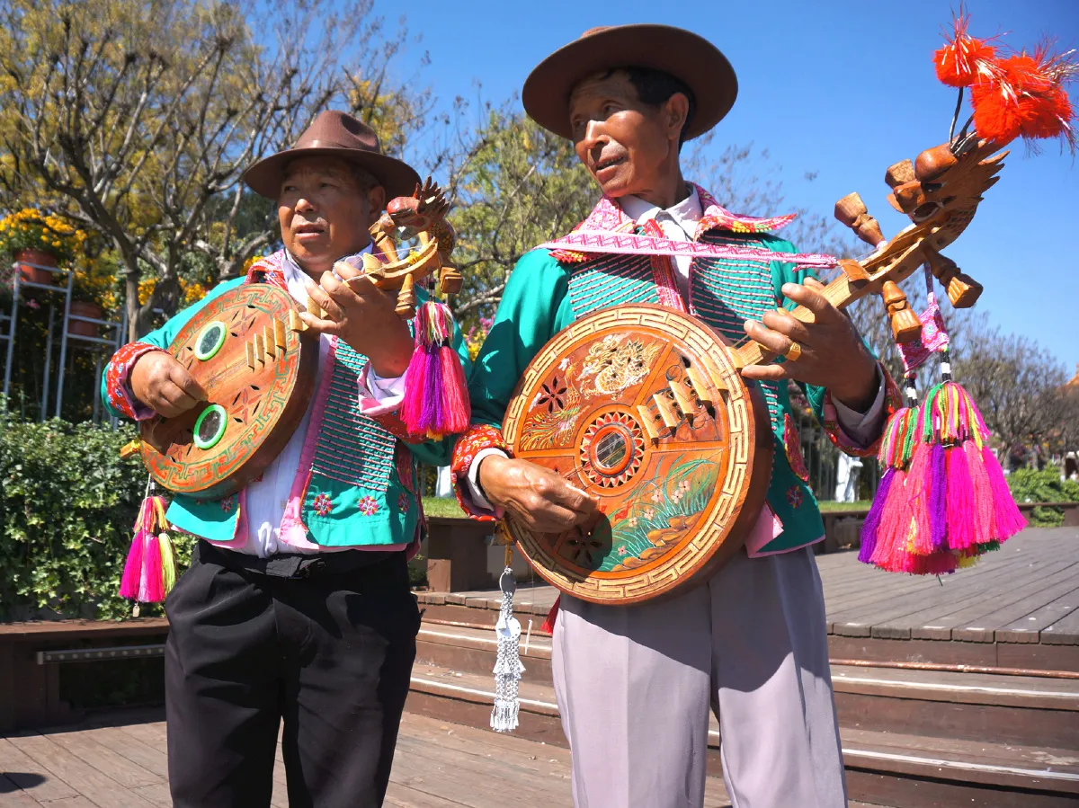 Yi musician playing the Moon Lute (circular lute instrument) in the mountains