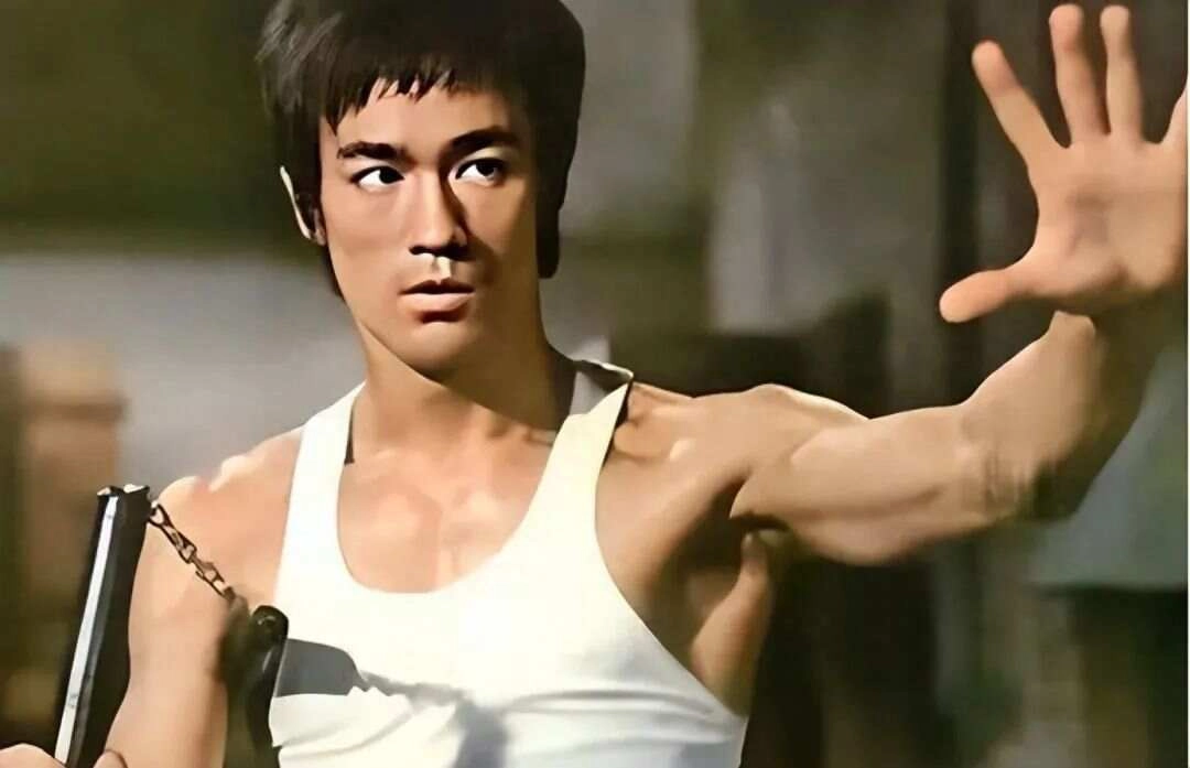 Bruce Lee performing a high kick in his iconic martial arts stance, showcasing his strength, speed, and agility.